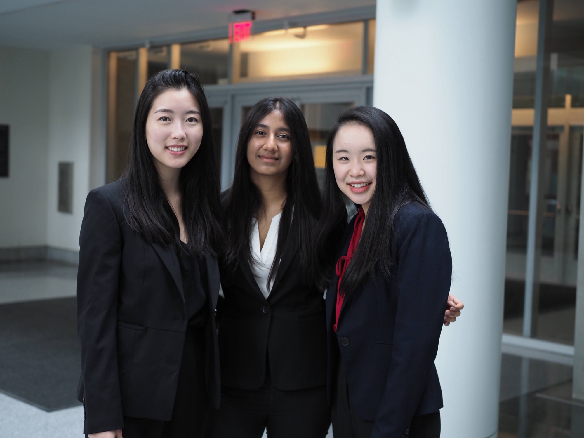 Three members together in the Sage Hall atrium
