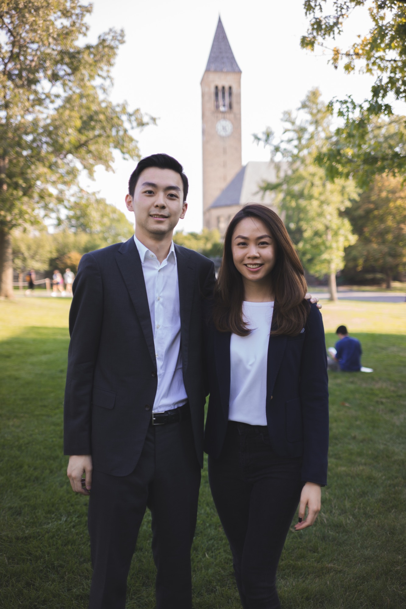 A mentor and his mentee standing together on the Arts Quad, McGraw Tower behind them